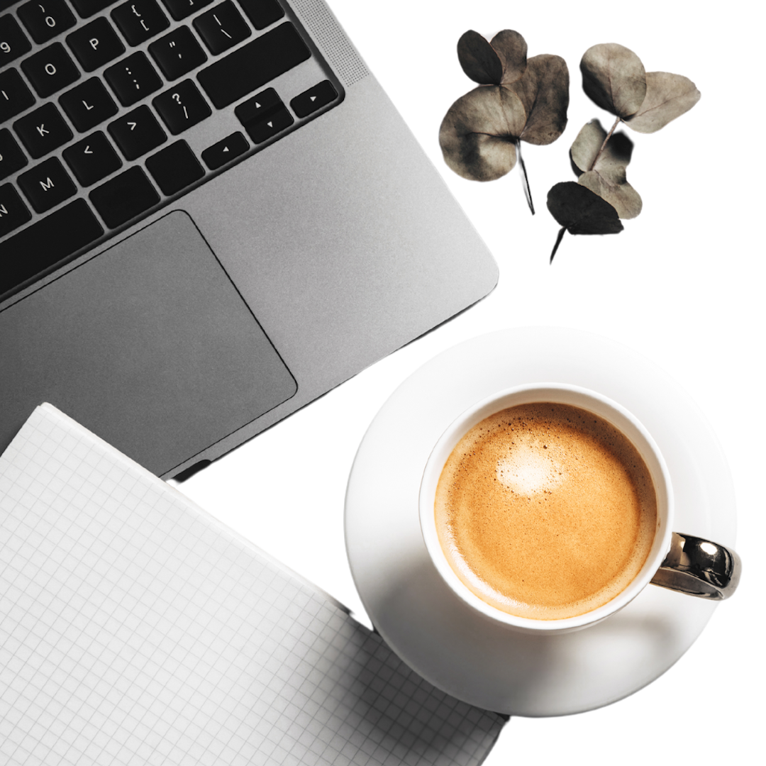 a laptop next to a cup of coffee and some leaves